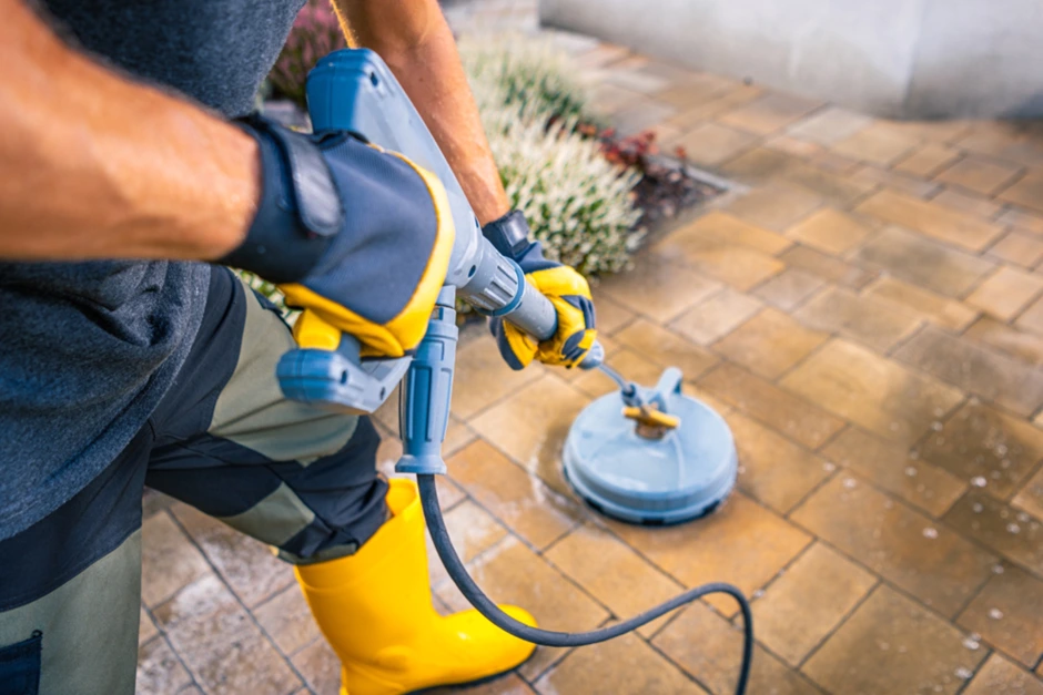 A man cleaning outdoor pavers using a scrubbing machine A man cleaning outdoor pavers using a scrubbing machine
