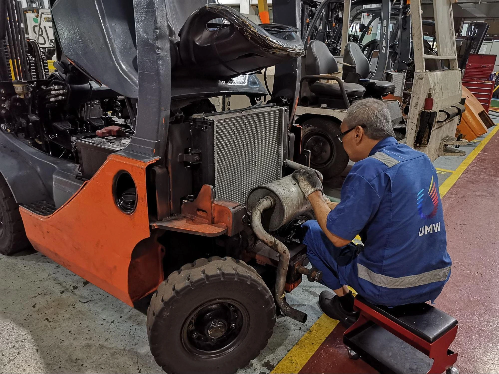 Modern Forklift for Manufacturing and Logistics A UMW staff working on a modern forklift inside a warehouse