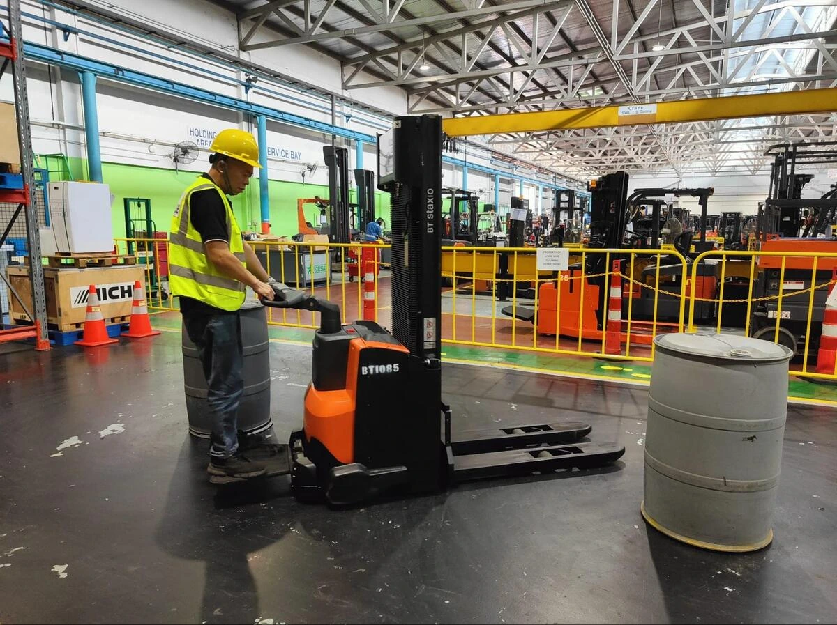 Efficient Warehouse Management and Pallet Truck Operation A warehouse operator attending training in UMW.