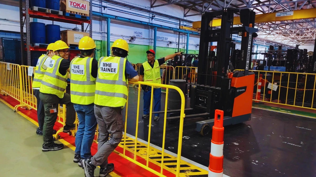 Forklift training session with trainees in Singapore Forklift training session in Singapore with trainees and an instructor beside a Toyota forklift.