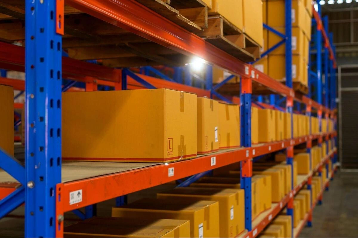 Selective Storage Racking with Cardboard Inventory Close-up of uniform cardboard boxes organized on heavy-duty selective storage racking beams, highlighting the clean layouts required for safe forklift Singapore logistics operations.